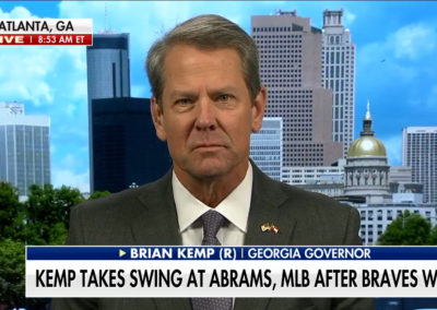 Gov. Brian Kemp in front of background image of Atlanta skyline including the Capitol building